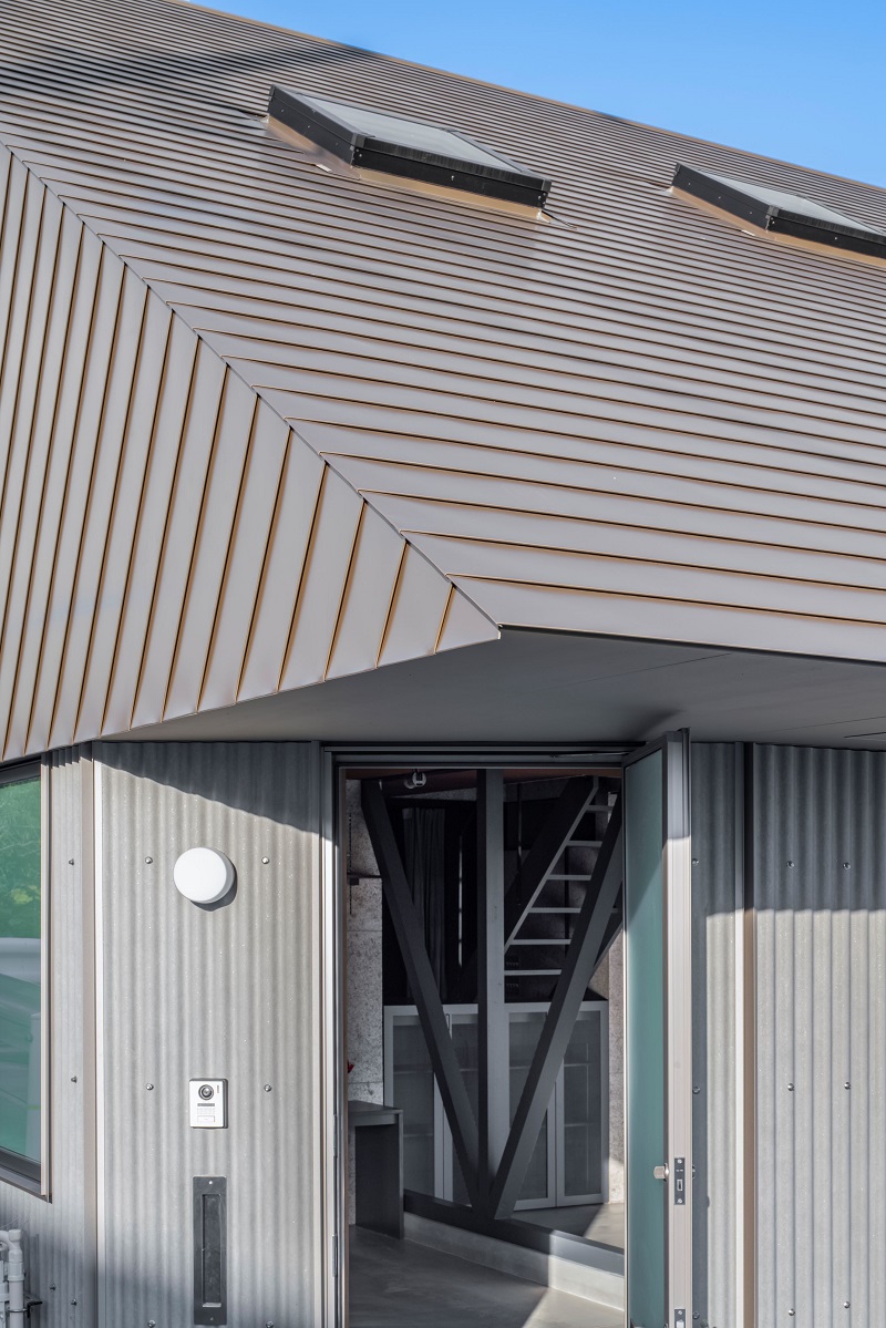 waved steel sheets enfold industrial-styled residence by slow architects