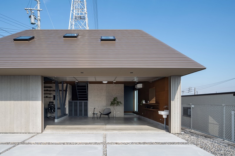 waved steel sheets enfold industrial-styled residence by slow architects