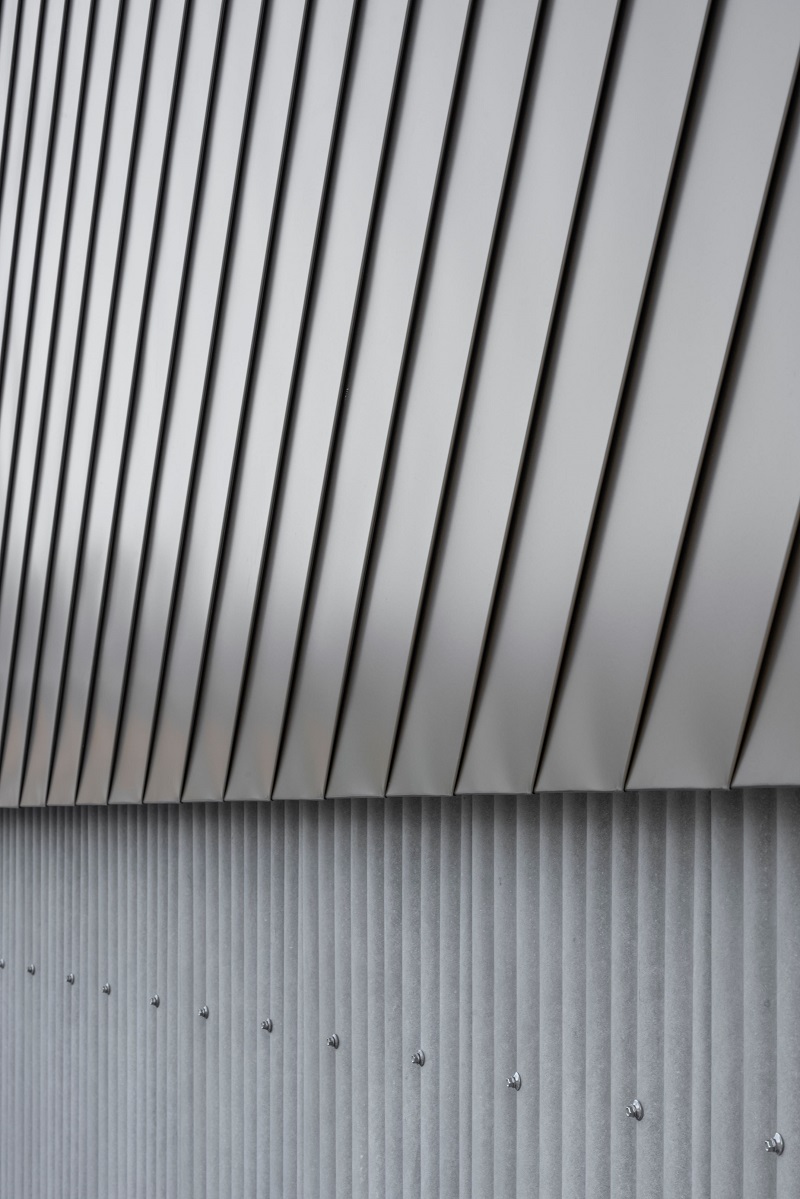 waved steel sheets enfold industrial-styled residence by slow architects