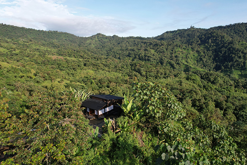 baquio arquitectura envuelve una zona de descanso con tablones de madera oscura en el bosque del Chocó en Ecuador