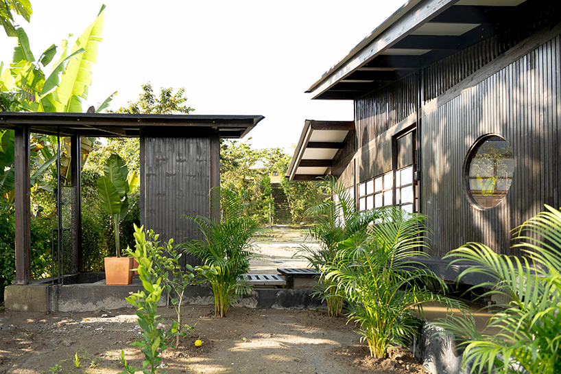baquio arquitectura envuelve una zona de descanso con tablones de madera oscura en el bosque del Chocó en Ecuador