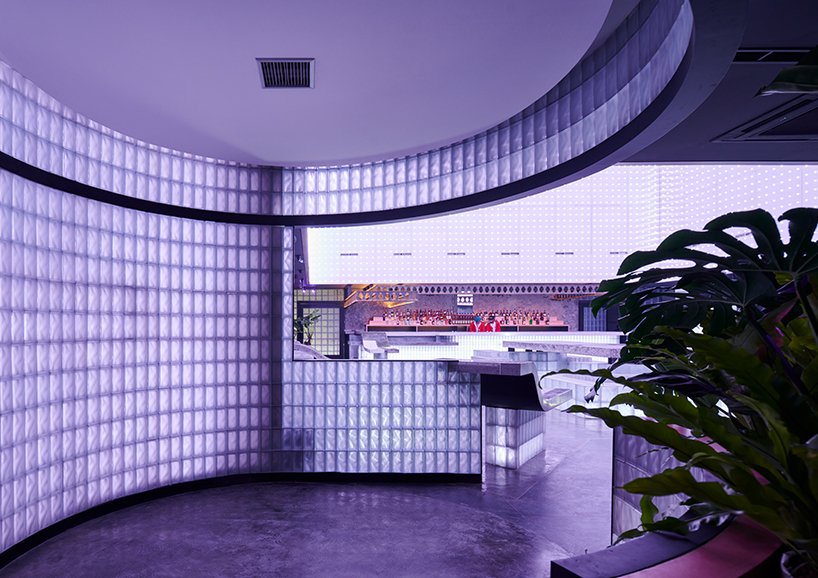 neon lights permeate glass block walls of renovated hidden basement bar in indonesia
