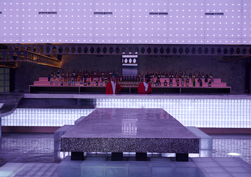 neon lights permeate glass block walls of renovated hidden basement bar in indonesia