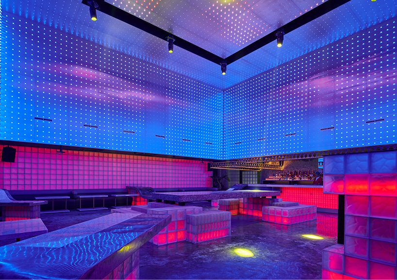 neon lights permeate glass block walls of renovated hidden basement bar in indonesia