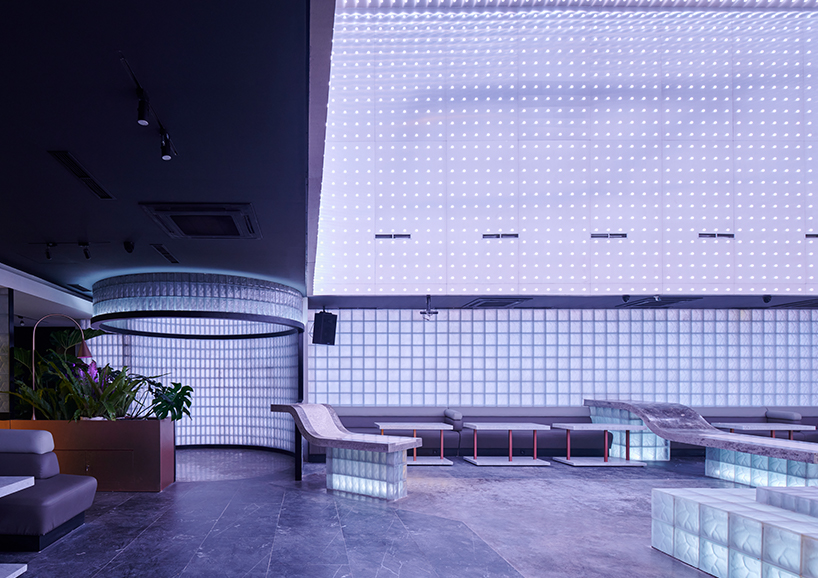 neon lights permeate glass block walls of renovated hidden basement bar in indonesia