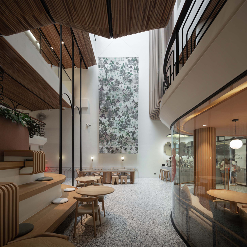 Μια χειροποίητη ξύλινη πρόσοψη διασχίζει τον ξενώνα του στούντιο σχεδιασμού VMA στην Μπανγκόκ