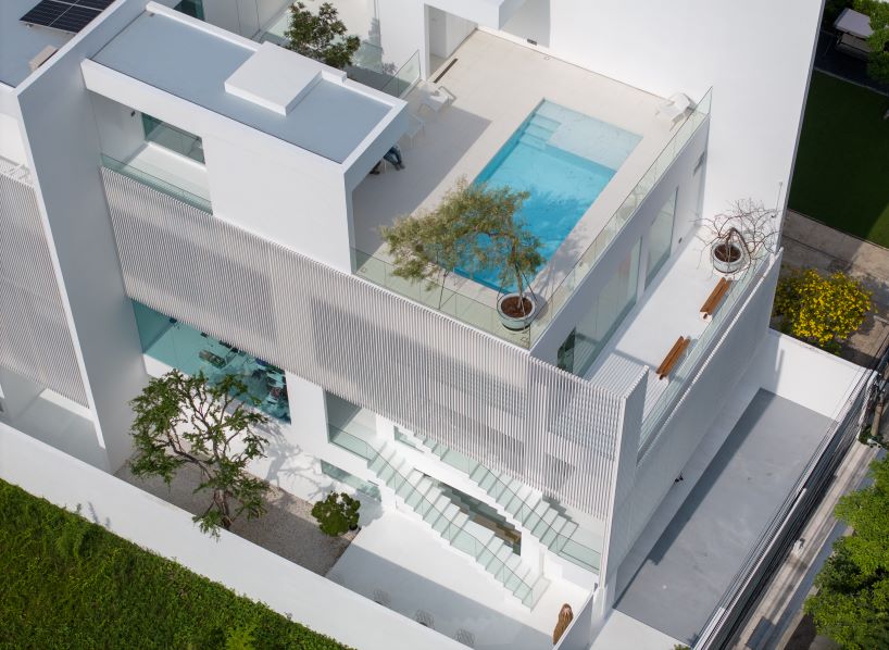 vertical white louvered surfaces enfold canvas house in bangkok