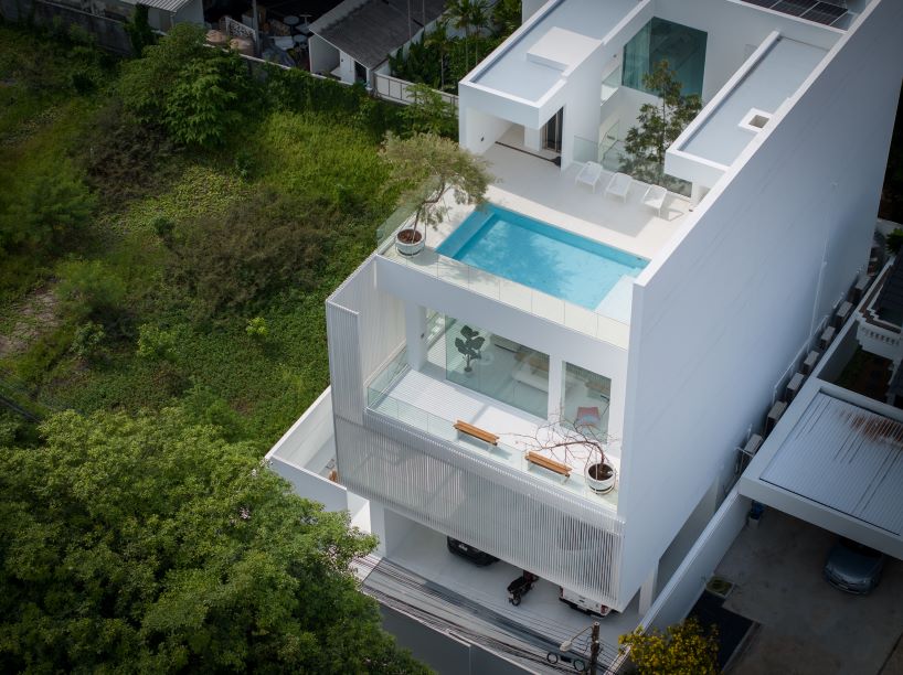 vertical white louvered surfaces enfold canvas house in bangkok