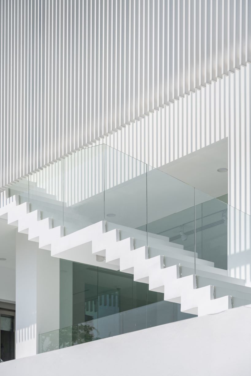 vertical white louvered surfaces enfold canvas house in bangkok