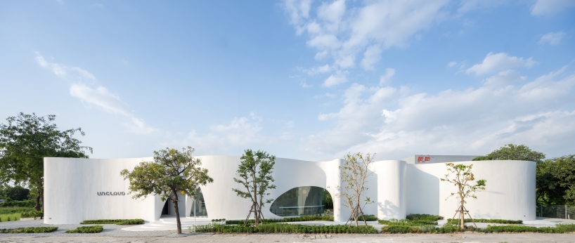 uncloud coffee's arching white structure integrates smoothly into its surroundings in thailand