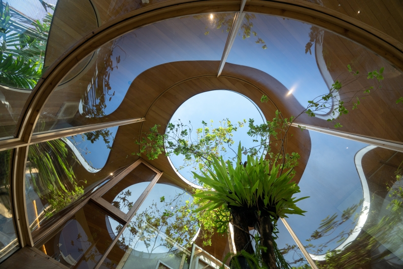 curved glass atriums penetrate residence&rsquo;s aluminum roof in bangkok
