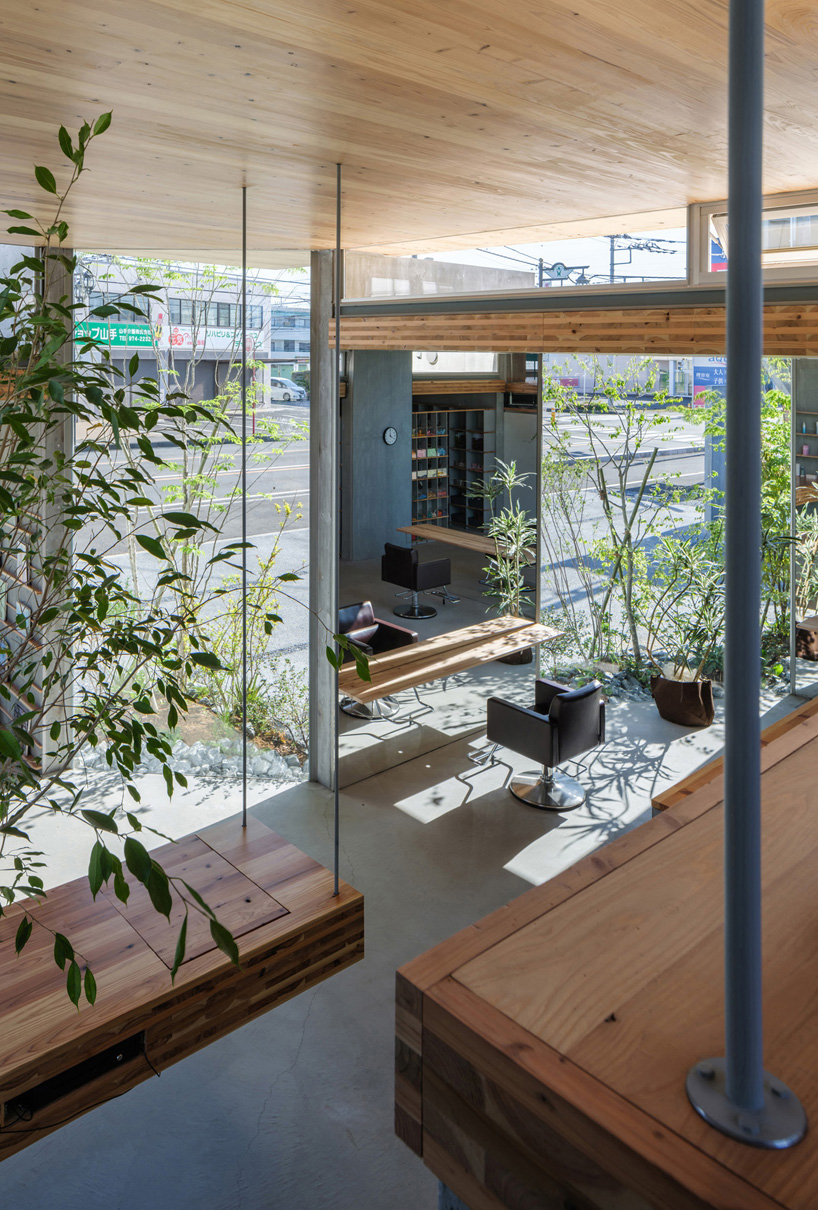 layers of wooden, concrete and mirrored surfaces combine to compose hair salon in japan