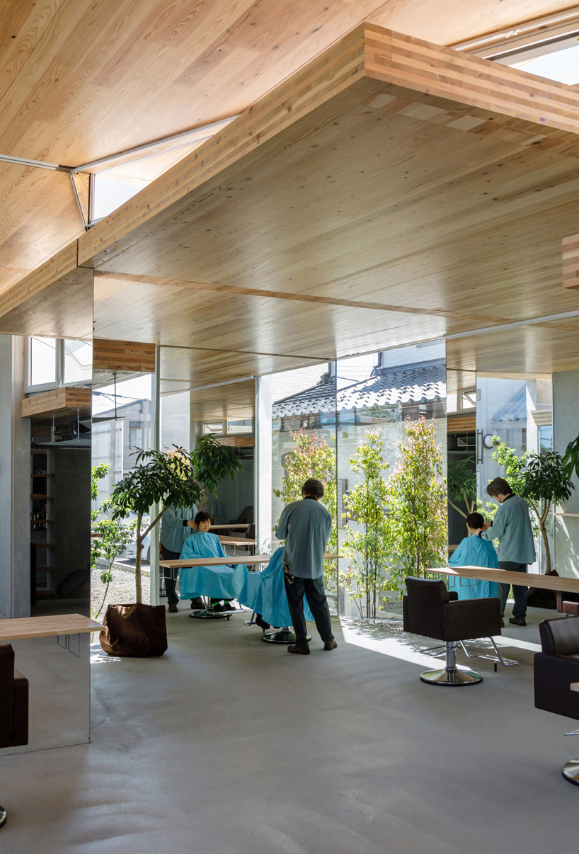 layers of wooden, concrete and mirrored surfaces combine to compose hair salon in japan