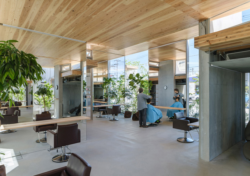 layers of wooden, concrete and mirrored surfaces combine to compose hair salon in japan