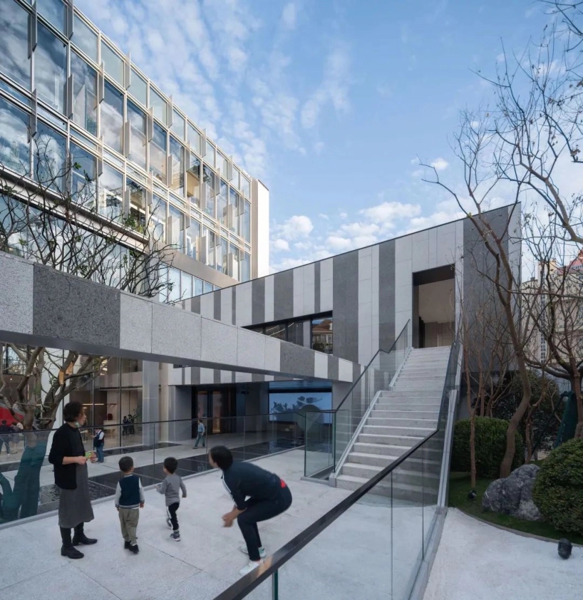 staggered reverse arc facade wraps jiangpu community culture and sports center in shanghai
