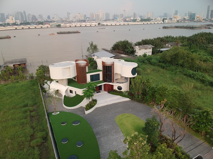 nest house's curved concrete forms shape a playful geometric composition in thailand