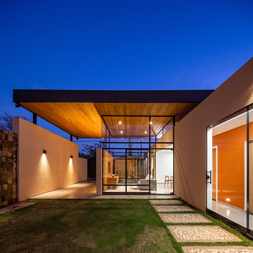 wood-clad cantilevers appear hovering above ser arquitetos' glass house in brazil