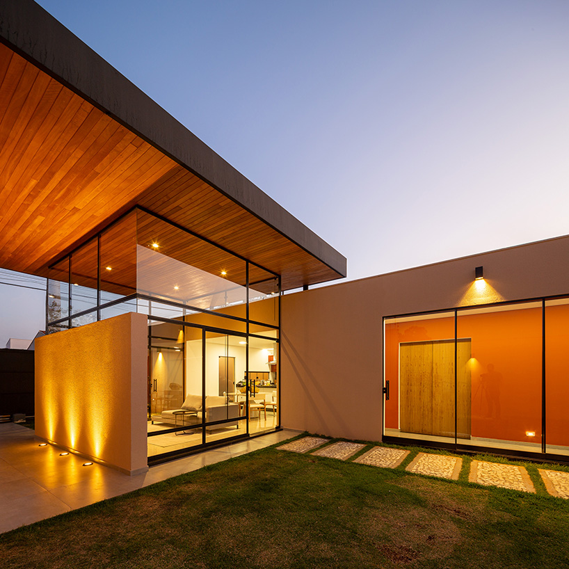 wood-clad cantilevers appear hovering above ser arquitetos' glass house in brazil