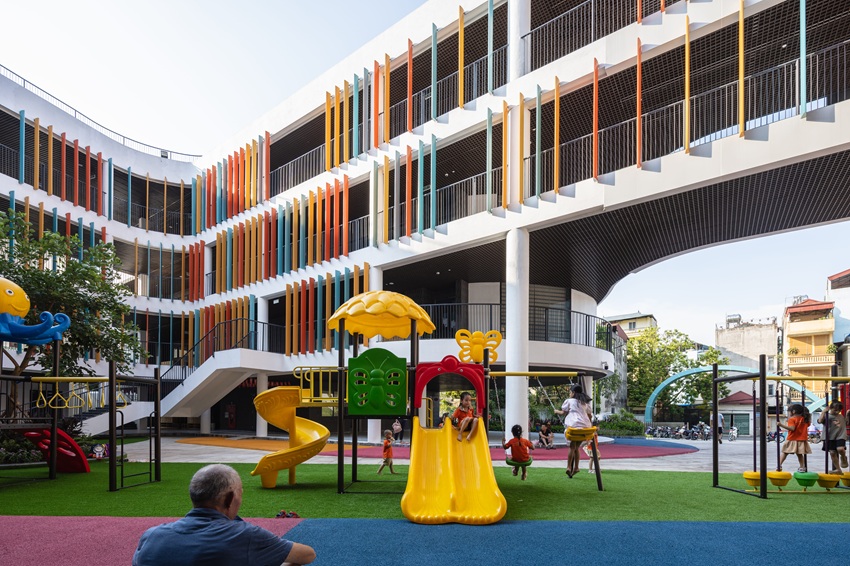 elliptical classroom volumes and colorful louvers shape courtyard kindergarten in hanoi - 2