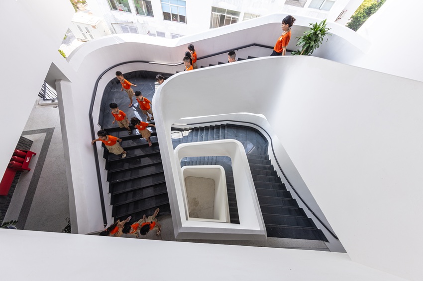 elliptical classroom volumes and colorful louvers shape courtyard kindergarten in hanoi - 8