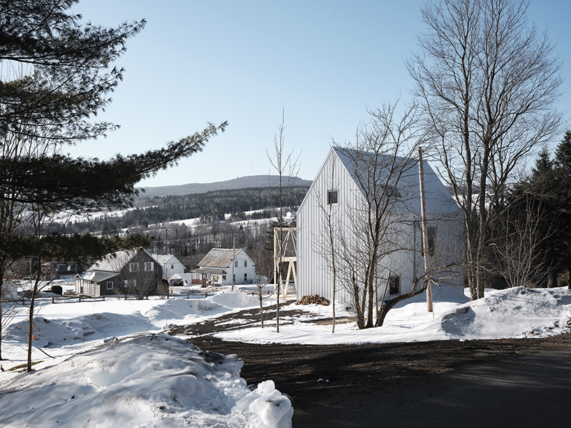 white cladding envelops la musette gabled village hut in canadian hillside