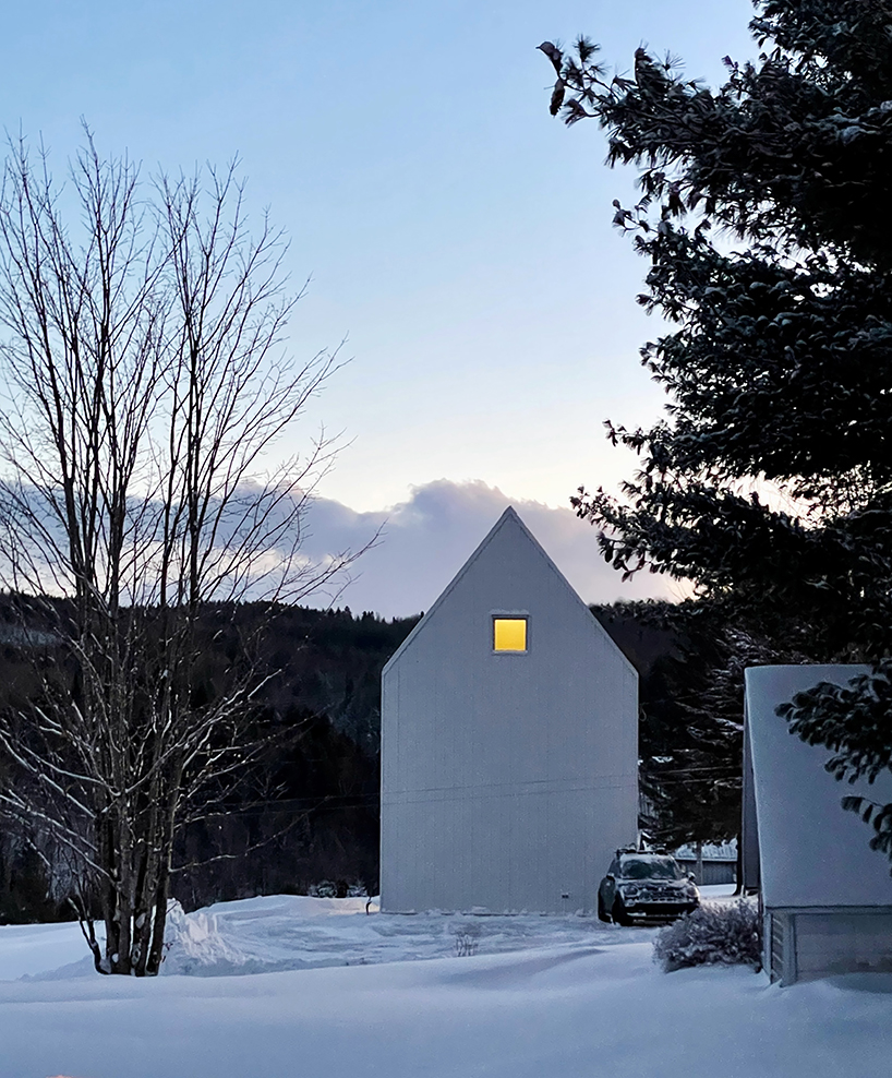 white cladding envelops la musette gabled village hut in canadian hillside