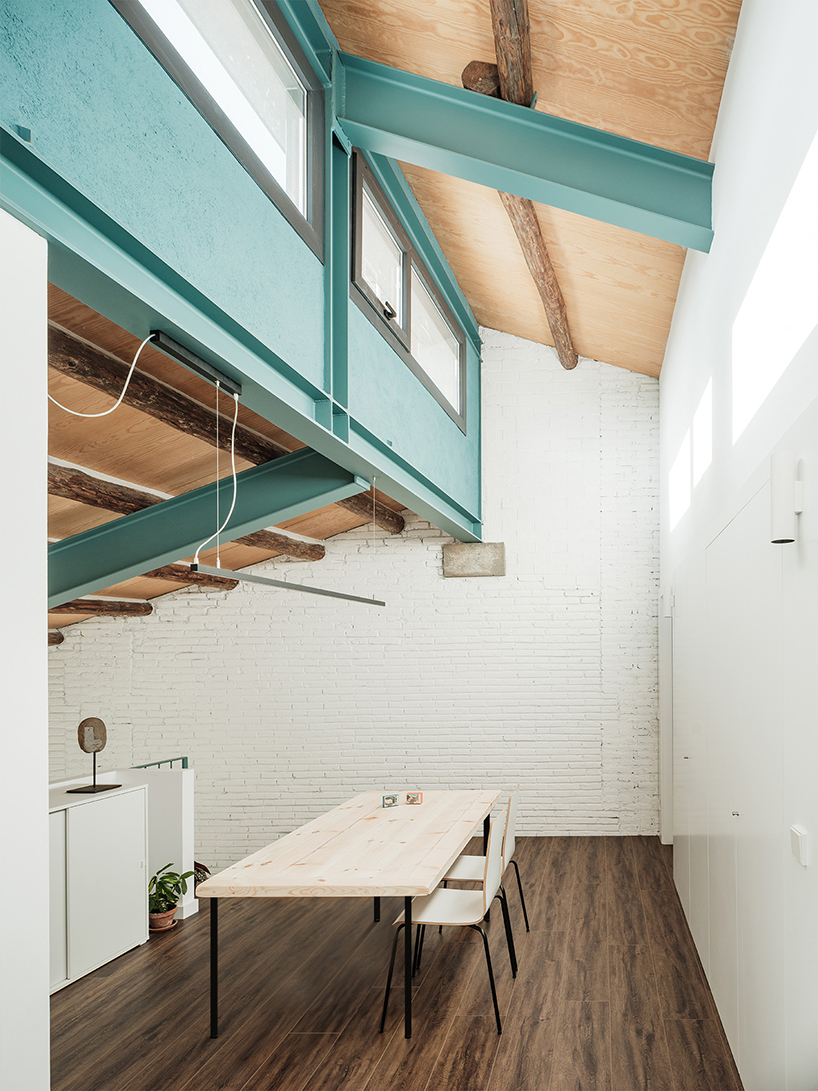repurposed wood shapes up the roof and furniture of converted warehouse in spain