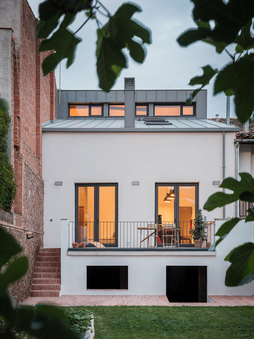 repurposed wood shapes up the roof and furniture of converted warehouse in spain