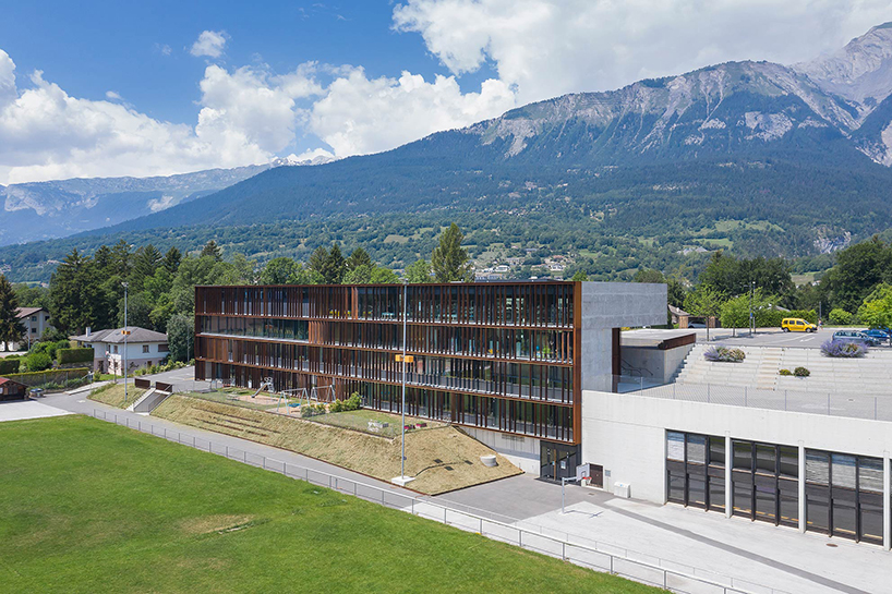 school expansion's louvered facade opens entirely toward the swiss alpine landscape