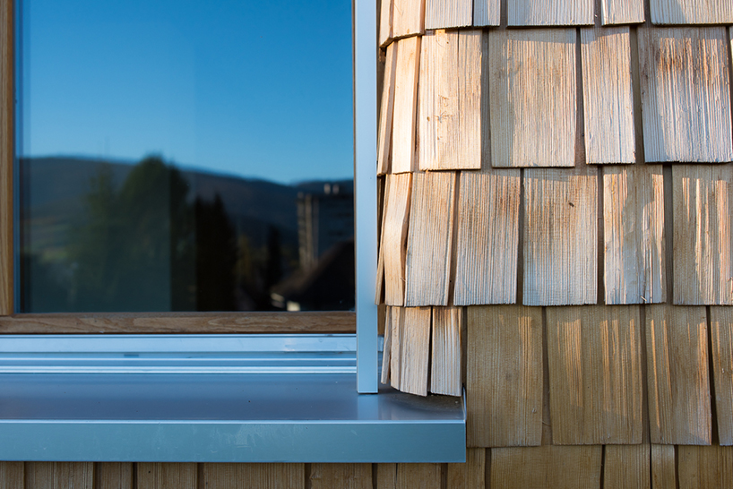 comamala ismail clothes residence's concrete structure with split fir shingles in switzerland