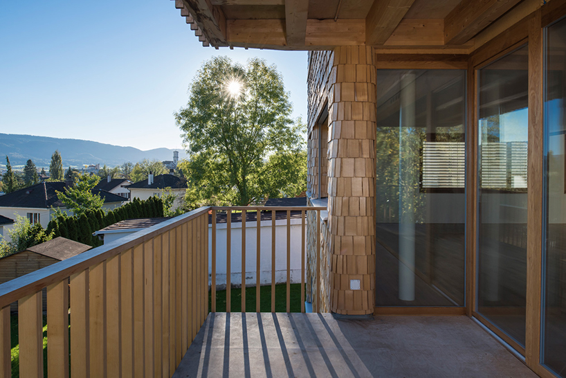 comamala ismail clothes residence's concrete structure with split fir shingles in switzerland