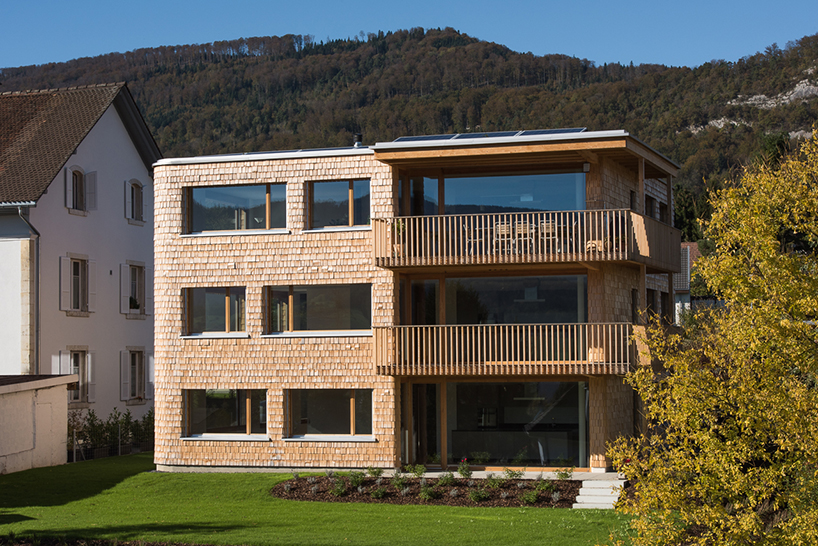 Gespaltene Tannenpaneele bedecken die Betonkonstruktion eines Mehrfamilienhauses in der Schweiz