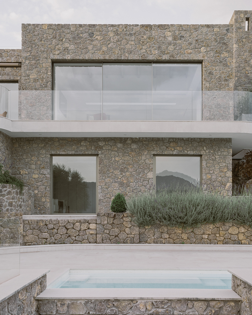 wrapped in stone, corfu house by georgios apostolopoulos overlooks the sea in greece