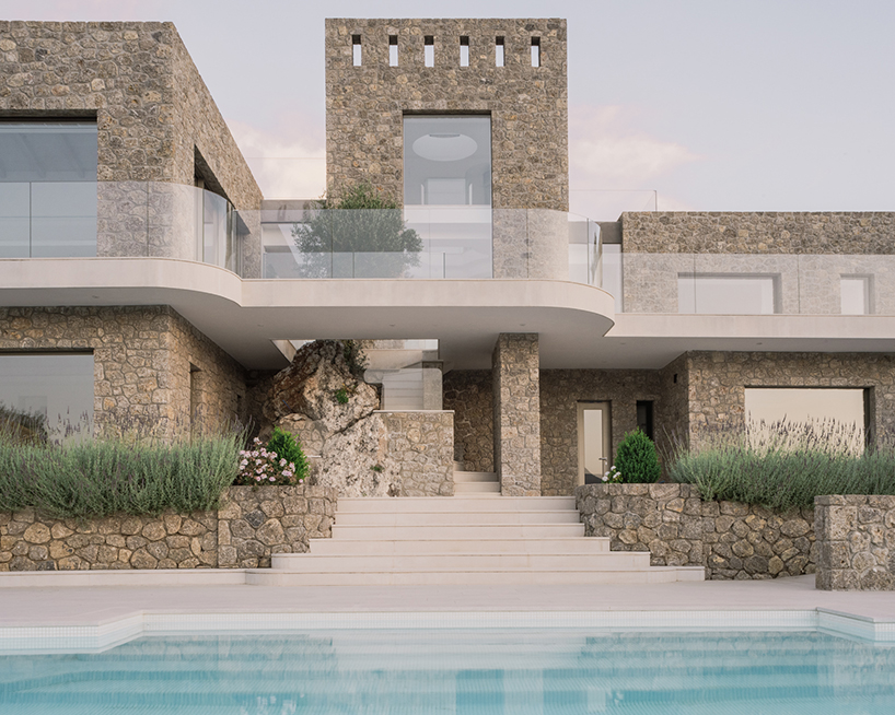 wrapped in stone, corfu house by georgios apostolopoulos overlooks the sea in greece