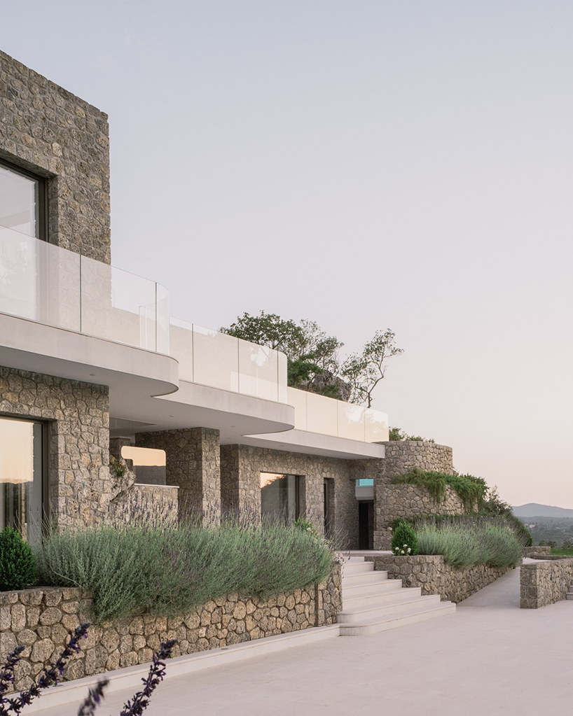 wrapped in stone, corfu house by georgios apostolopoulos overlooks the sea in greece