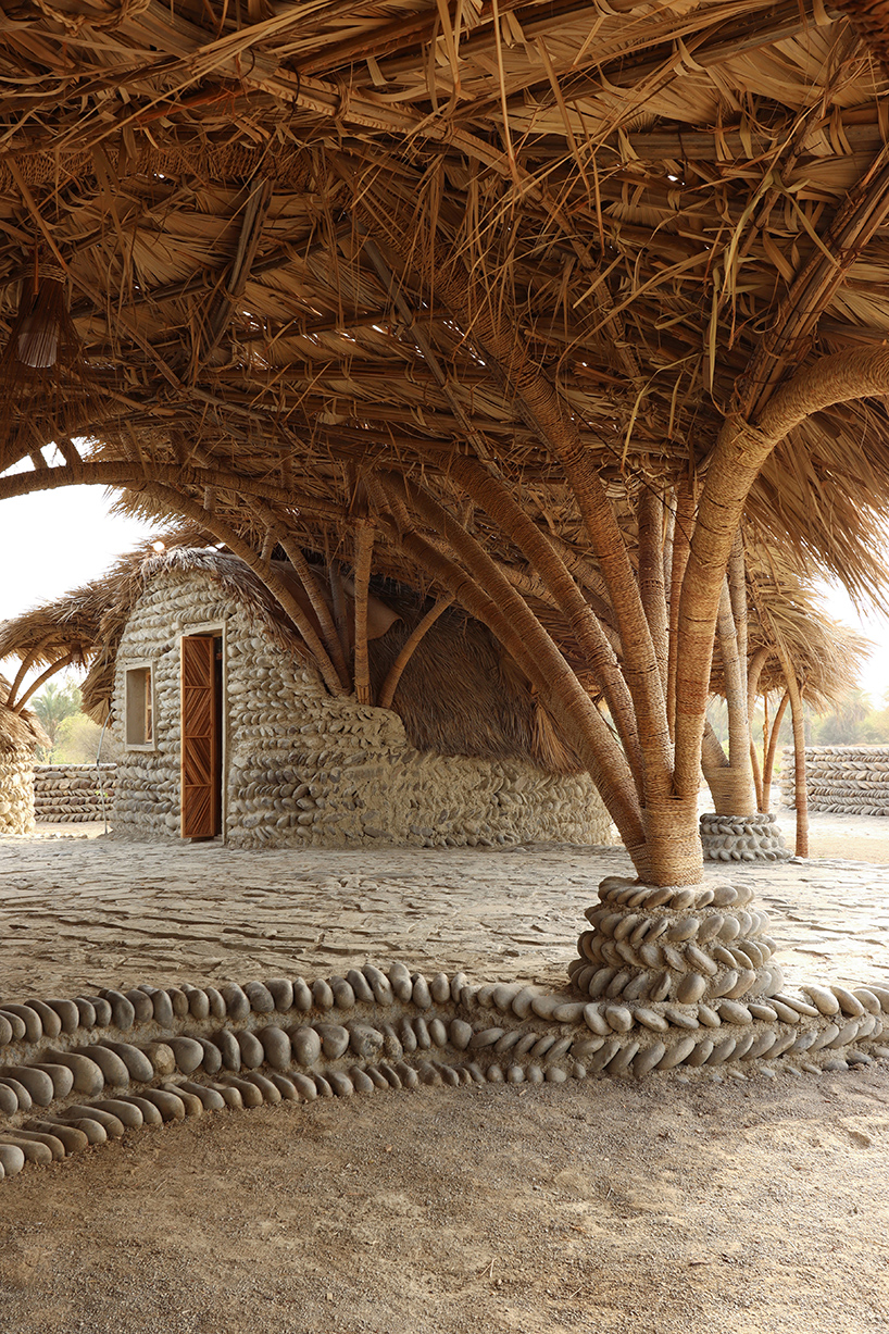 vaulted palm canopy shields dry stone guesthouse cluster in southeastern iran