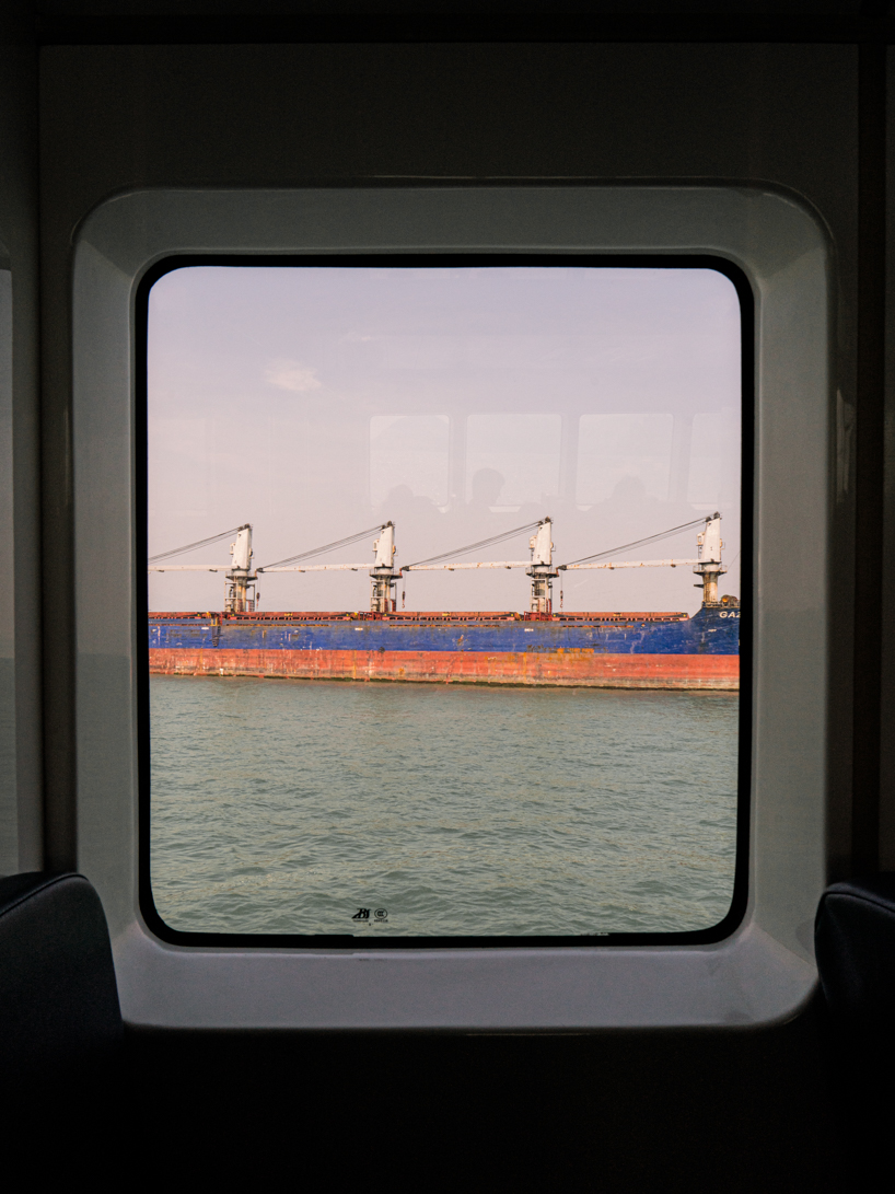 photographer captures cargo ships passing by on his ferry ride home