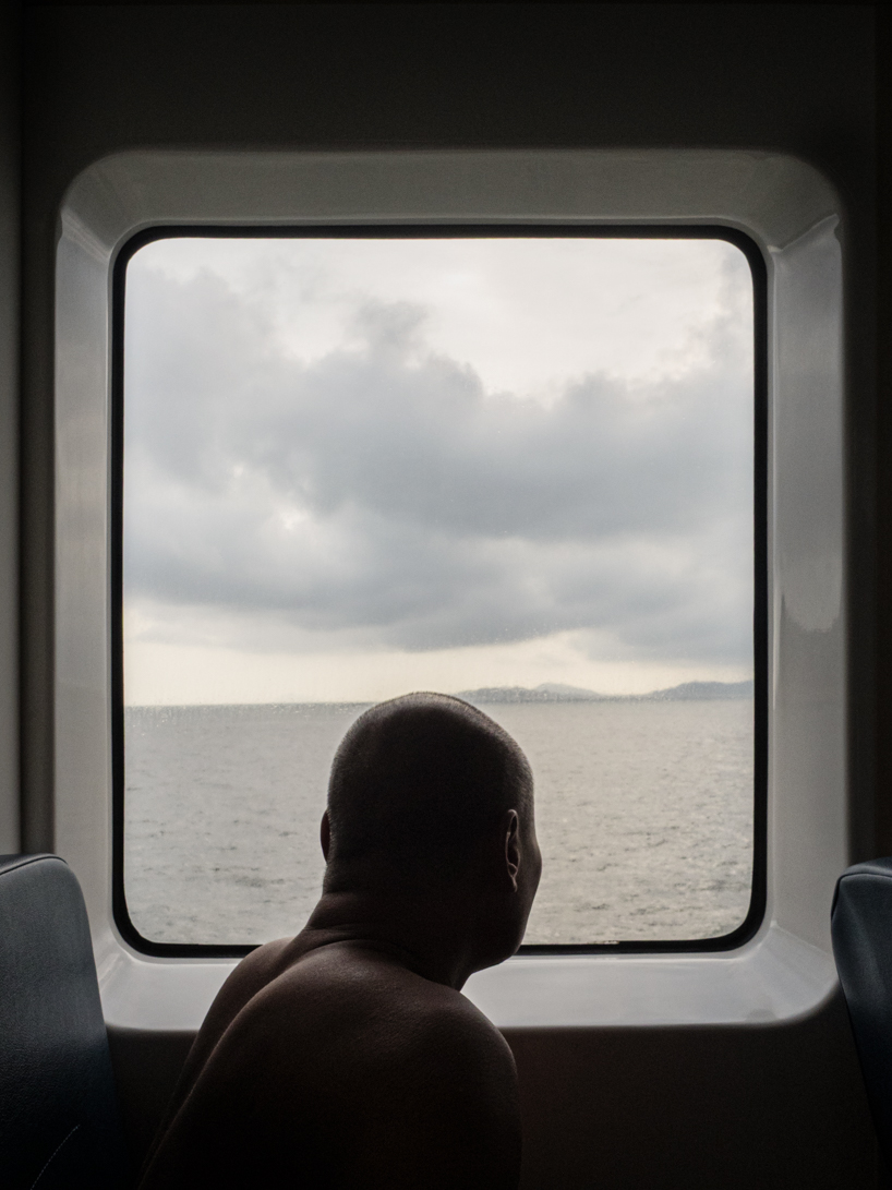photographer captures cargo ships passing by on his ferry ride home