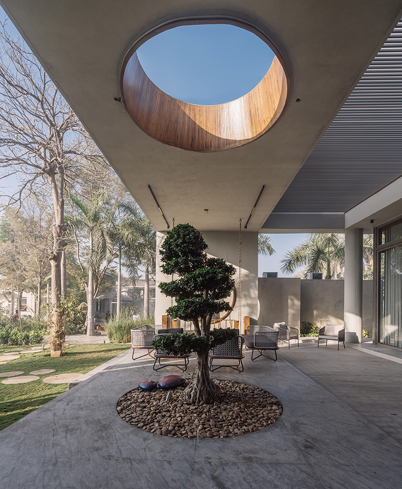 circular wooden apertures puncture through multi-use pavilion by UA lab in india