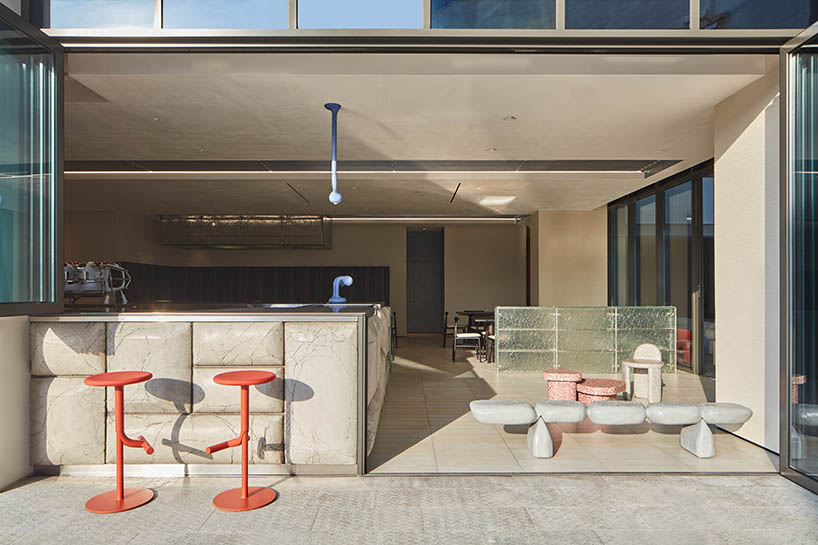 a box-like chandelier, concrete pillow bar, and icy walls enliven cafe by tee vee eff in dubai
