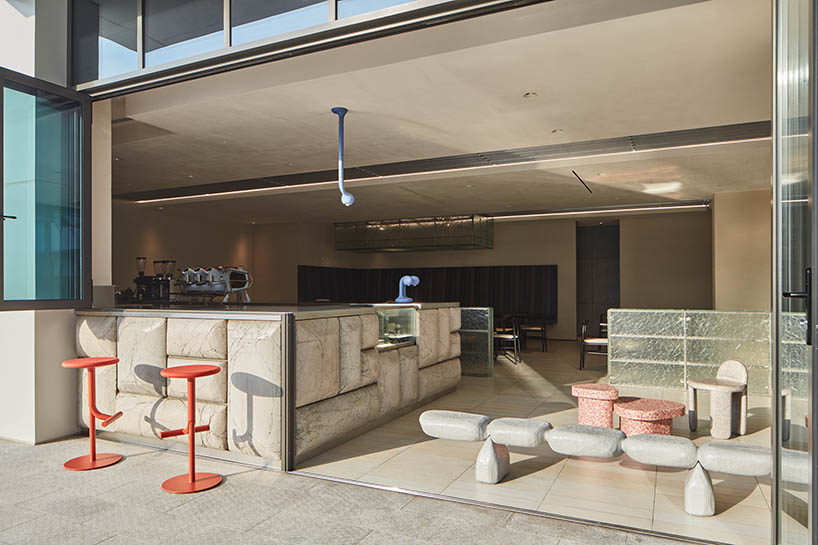 a box-like chandelier, concrete pillow bar, and icy walls enliven cafe by tee vee eff in dubai