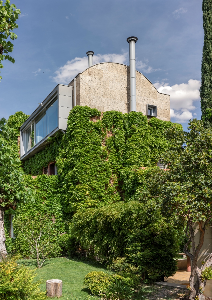 eme 157's domehome emerges from foliage-covered brick house in spain