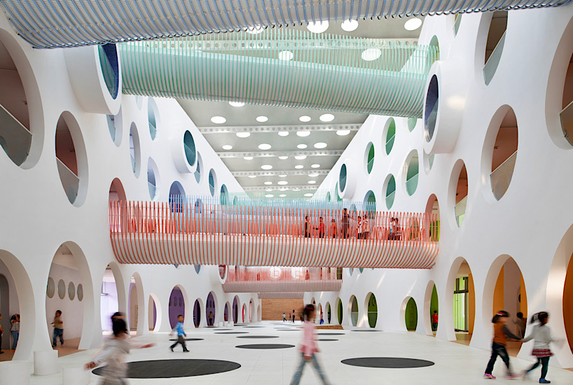 Twelve colorful bridges hang over the atrium of the Zickzack primary school by SAKO architects