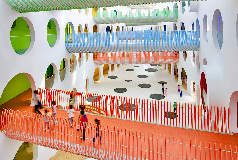 Twelve colorful bridges hang over the atrium of the Zickzack primary school by SAKO architects