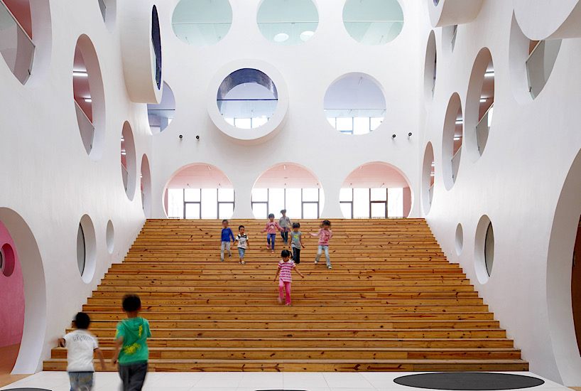 Twelve colorful bridges hang over the atrium of the Zickzack primary school by SAKO architects