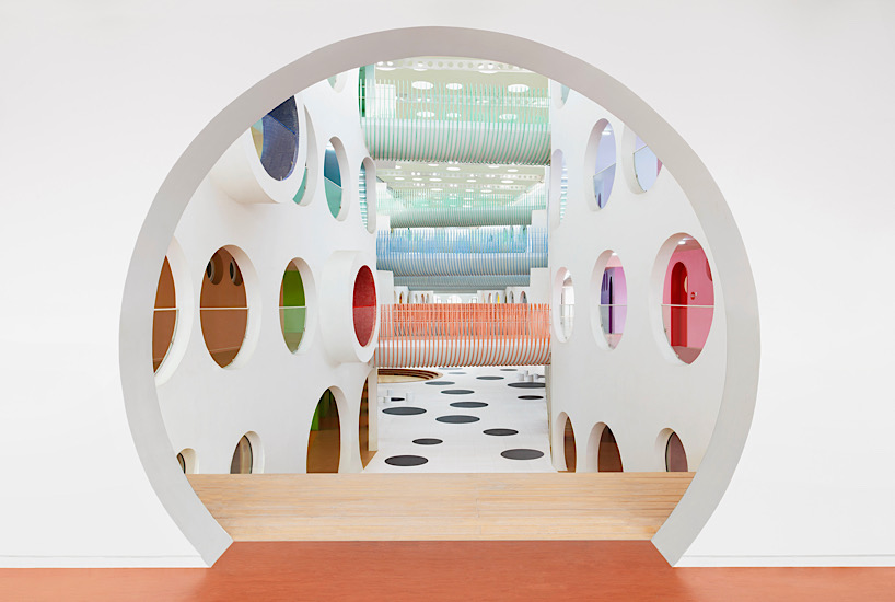 Twelve colorful bridges hang over the atrium of the Zickzack primary school by SAKO architects