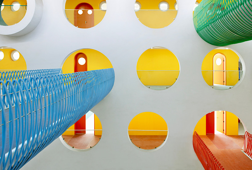 Twelve colorful bridges hang over the atrium of the Zickzack primary school by SAKO architects