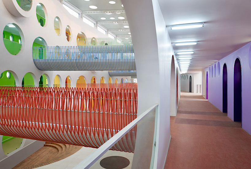 Twelve colorful bridges hang over the atrium of the Zickzack primary school by SAKO architects