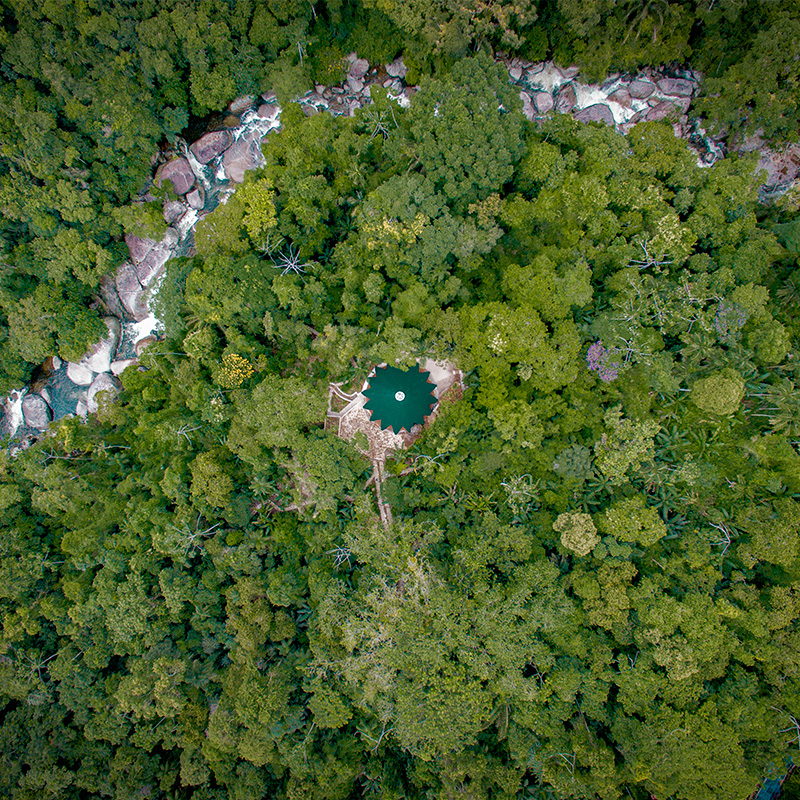 ceramic tiles in blue and green hues cover tapered ayuru forest temple in brazil