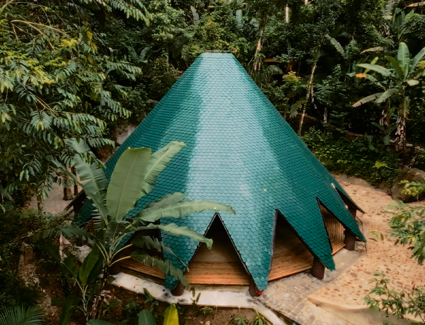 ceramic tiles in blue and green hues cover tapered ayuru forest temple in brazil